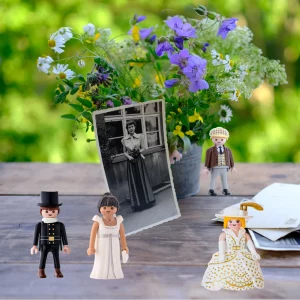 mesa con recuerdos y fotos antiguas y muñecos de Plaumobile representando a las personas que se encuentran en las fotos. Simulando una sesión individual de Constelaciones Familiares.